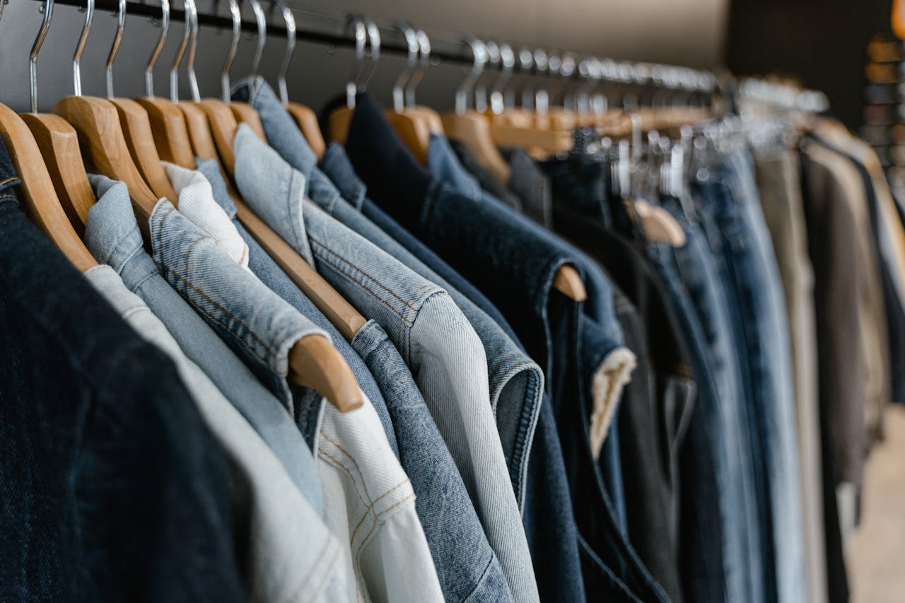services-01 A close-up view of various denim jackets hanging on a clothes rack indoors.